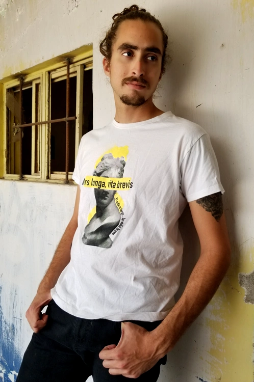 Artist portrait posing with his design printed on a shirt